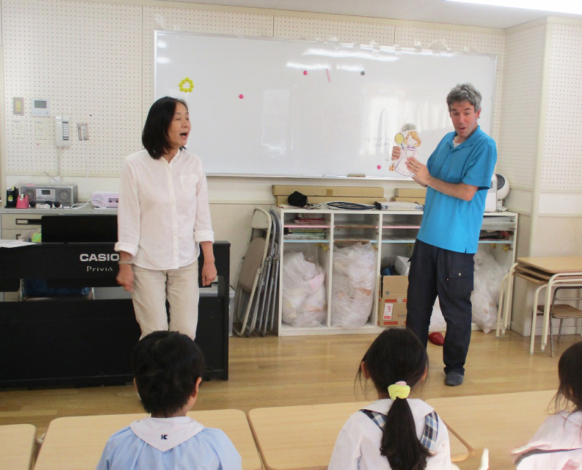 2人の先生が子どもたちの前で話しています。