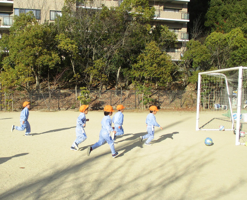 園庭で子どもたちがサッカーをしています。