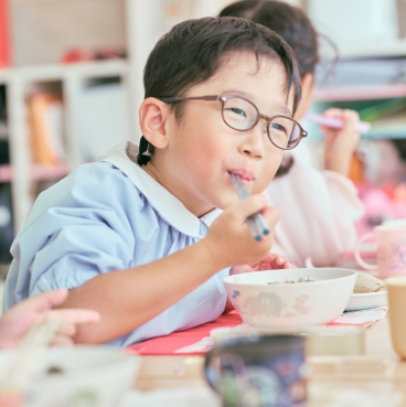 男の子が給食を美味しそうな表情で食べています。