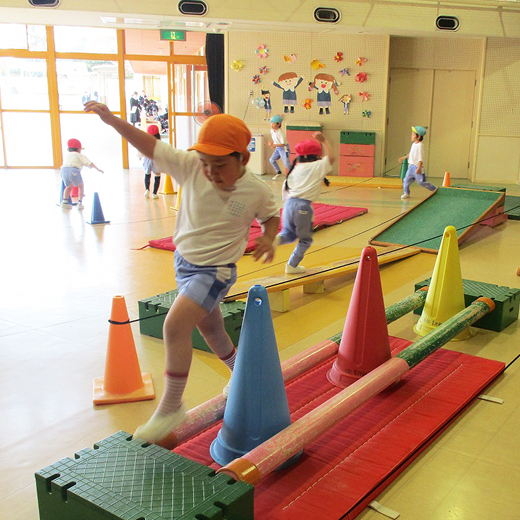 子どもたちが室内で体育遊びをしています。