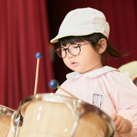 女の子が真剣な表情で鍵盤楽器を演奏しています。
